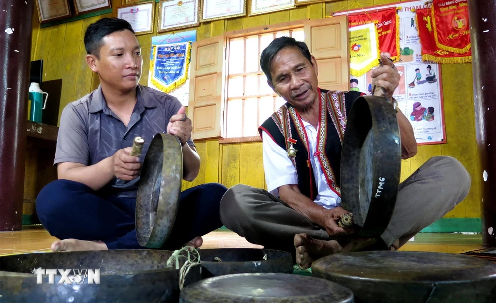 Già Đinh Y Khoa truyền dạy cồng chiêng cho thế hệ trẻ trong thôn nhằm bảo tồn, giữ gìn bản sắc văn hóa truyền thống của dân tộc. (Ảnh: Lê Phước Ngọc/TTXVN)