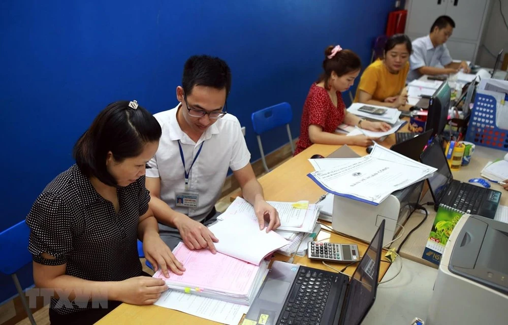 Cán bộ thuế tỉnh Thái Nguyên hướng dẫn doanh nghiệp Công ty Thép Việt Cường khai báo thủ tục giãn thuế. (Ảnh: Danh Lam/TTXVN)
