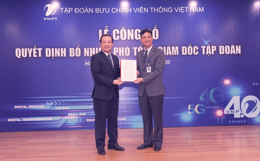 Ông Phạm Đức Long trao quyết định Phó Tổng Giám đốc cho ông Nguyễn Nam Long (phải). (Ảnh: CTV/Vietnam+)