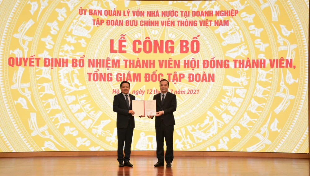 Chủ tịch Hội đồng thành viên Tập đoàn VNPT Phạm Đức Long (phải) trao quyết định bổ nhiệm ông Huỳnh Quang Liêm giữ chức vụ Tổng giám đốc VNPT. (Ảnh: T.Q/Vietnam+)