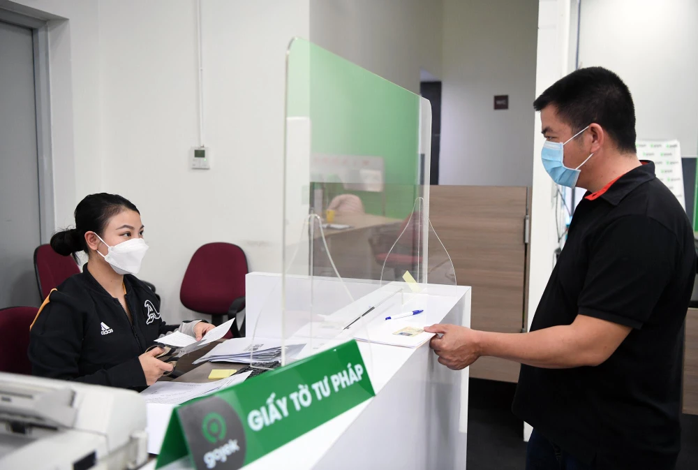 Văn phòng của Gojek được chia thành các khu vực đảm bảo giãn cách, yêu cầu nghiêm ngặt về đo nhiệt độ, đeo khẩu trang và khử khuẩn. (Ảnh: V.C/Vietnam+)