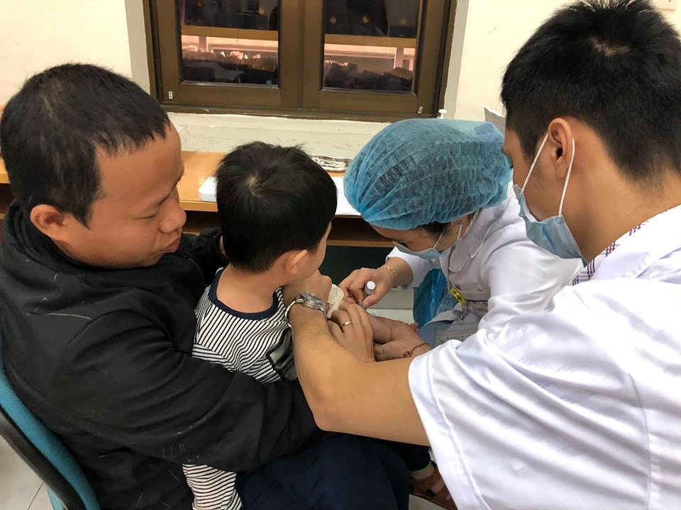 Bác sỹ lấy máu xét nghiệm cho trẻ. (Ảnh: PV/Vietnam+)