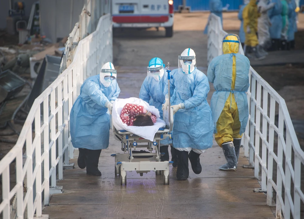 Nhân viên y tế vận chuyển người mắc bệnh COVID-19 tới bệnh viện dã chiến tại Vũ Hán. (Ảnh: THX/TTXVN)