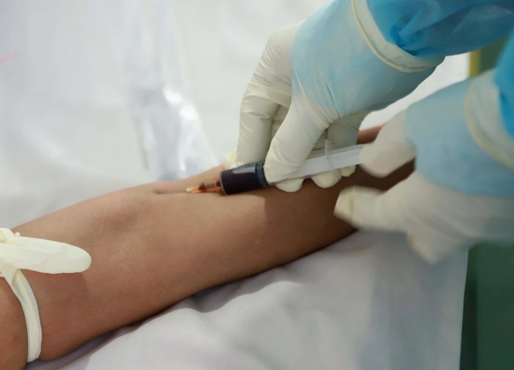 Lấy mẫu máu xét nghiệm COVID-19 cho người dân. (Ảnh: Hoàng Hùng/TTXVN)