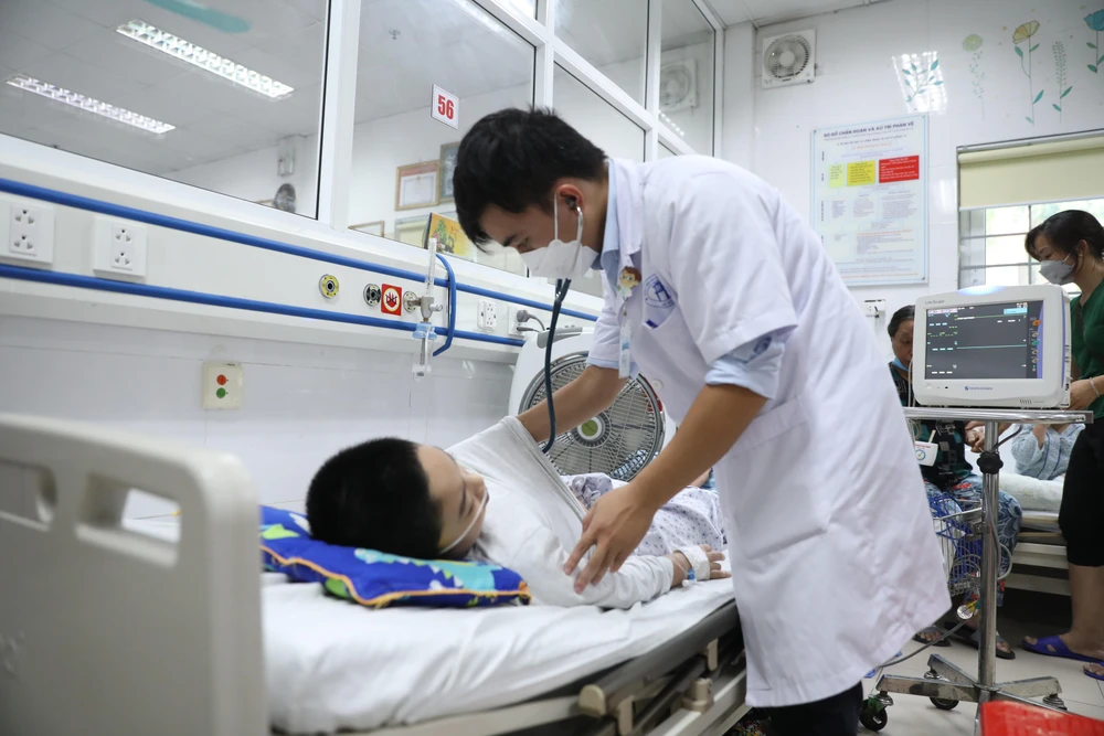 Bác sỹ tại Bệnh viện Xanh Pôn khám cho một bệnh nhi mắc sốt xuất huyết trong tình trạng nặng. (Ảnh: PV/Vietnam+)