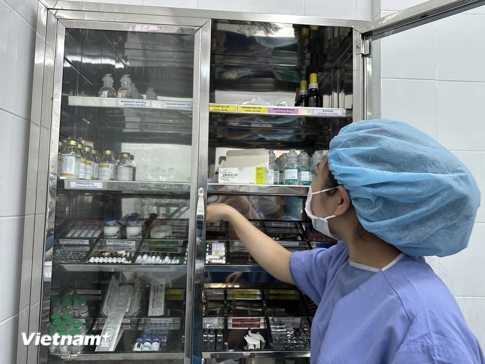 Nhân viên y tế kiểm tra tủ thuốc. (Ảnh: T.G/Vietnam+)