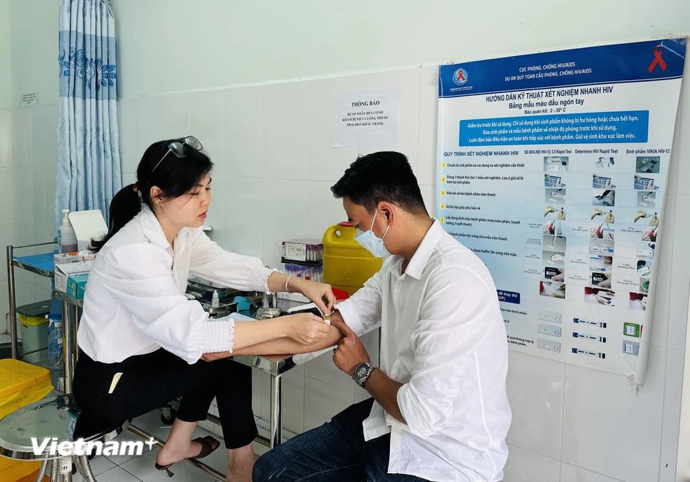 Nhân viên y tế Trung tâm Kiểm soát bệnh tật tỉnh Kiên Giang lấy mẫu xét nghiệm theo dõi điều trị HIV cho một bệnh nhân. (Ảnh: T.G/Vietnam+)