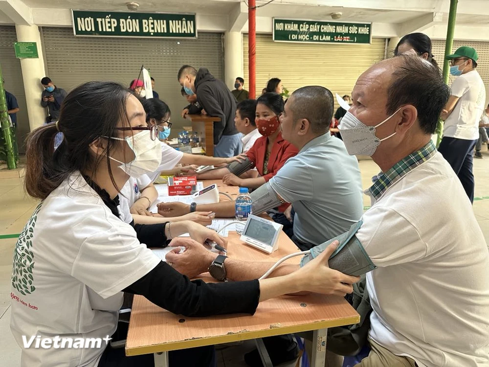 Nhân viên y tế đo huyết áp cho người dân. (Ảnh: T.G/Vietnam+)
