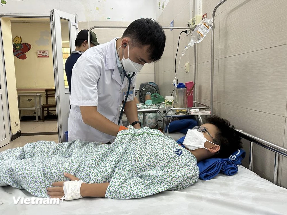 Bác sỹ Bệnh viện Xanh Pôn khám, theo dõi sức khỏe cho một bệnh nhi mắc bệnh truyền nhiễm. (Ảnh: T.G/Vietnam+)