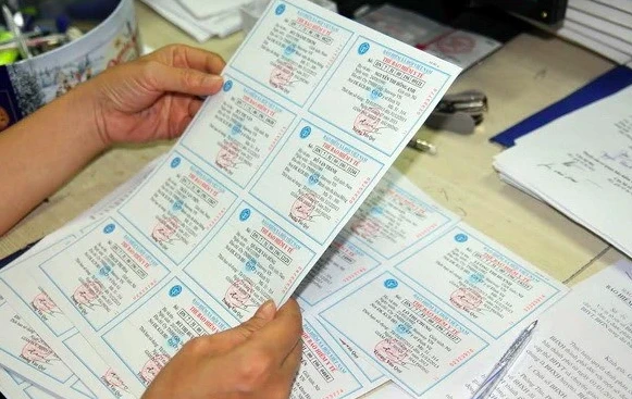 Kiểm tra thẻ bảo hiểm y tế trước khi phát cho người dân. (Ảnh: PV/Vietnam+)
