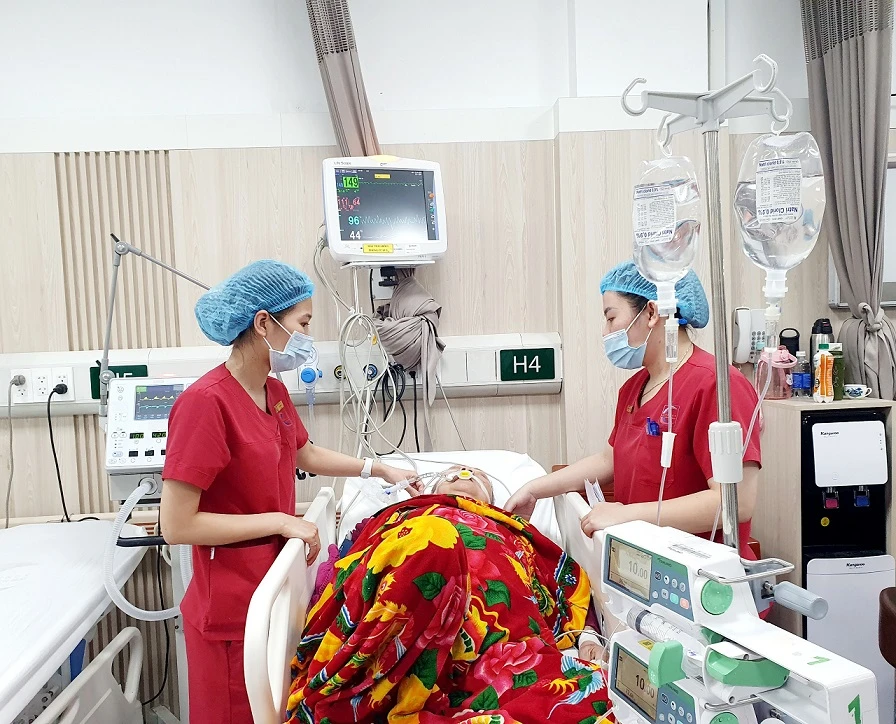 Điều dưỡng Đặng Thị Hạ chăm sóc cho một bệnh nhân tại Bệnh viện Bạch Mai. (Ảnh: M.T/Vietnam+)
