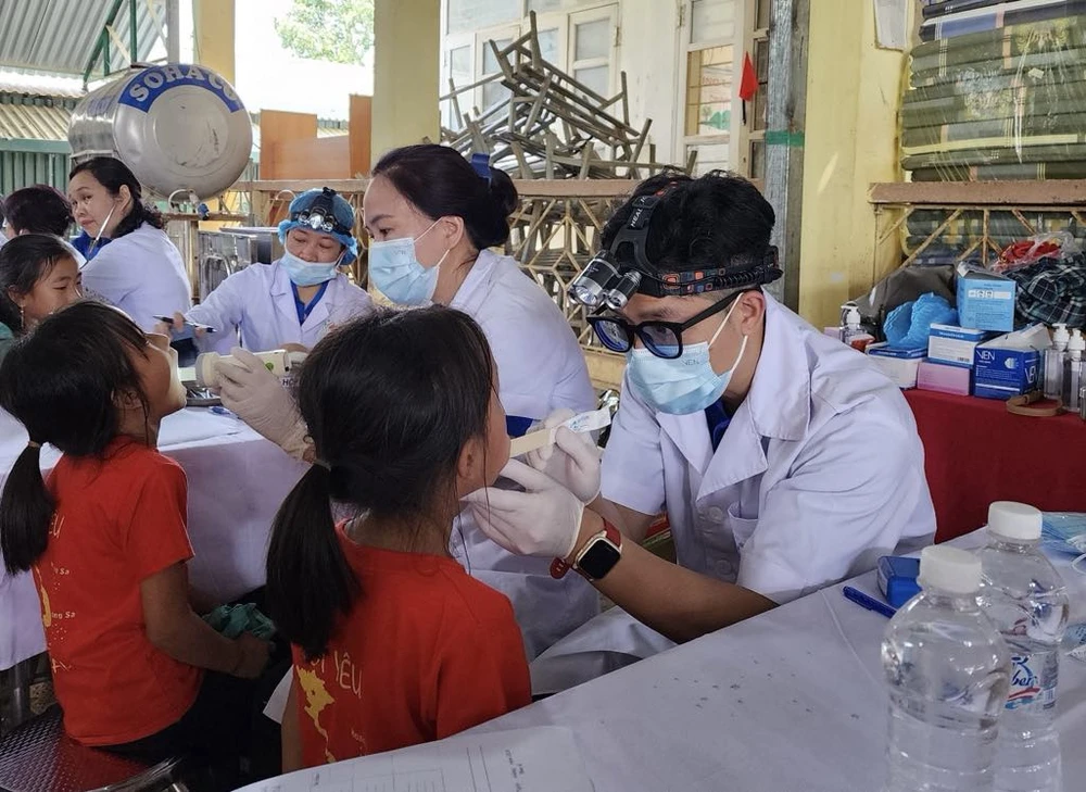 Bác sĩ Bệnh viện Hữu nghị Việt Nam-Cu Ba khám răng miệng cho học sinh trong chương trình. (Ảnh: PV/Vietnam+)