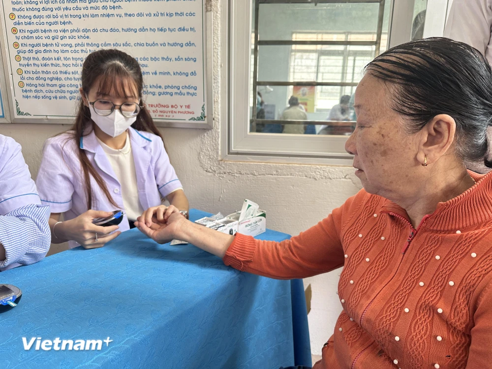 Nhân viên y tế theo dõi, kiểm tra các chỉ số đường huyết cho người dân. (Ảnh: T.G/Vietnam+)