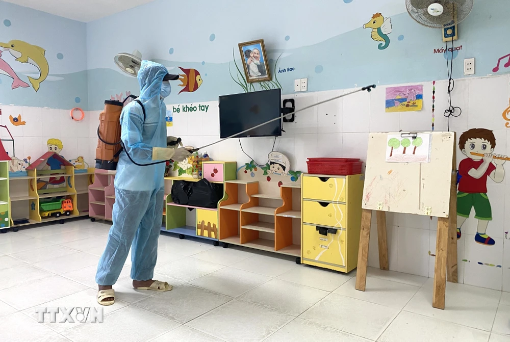 Lực lượng chức năng phun thuốc tiêu độc khử trùng tại các trường mầm non, mẫu giáo có trẻ mắc bệnh tay chân miệng. (Ảnh: Tường Quân/TTXVN)