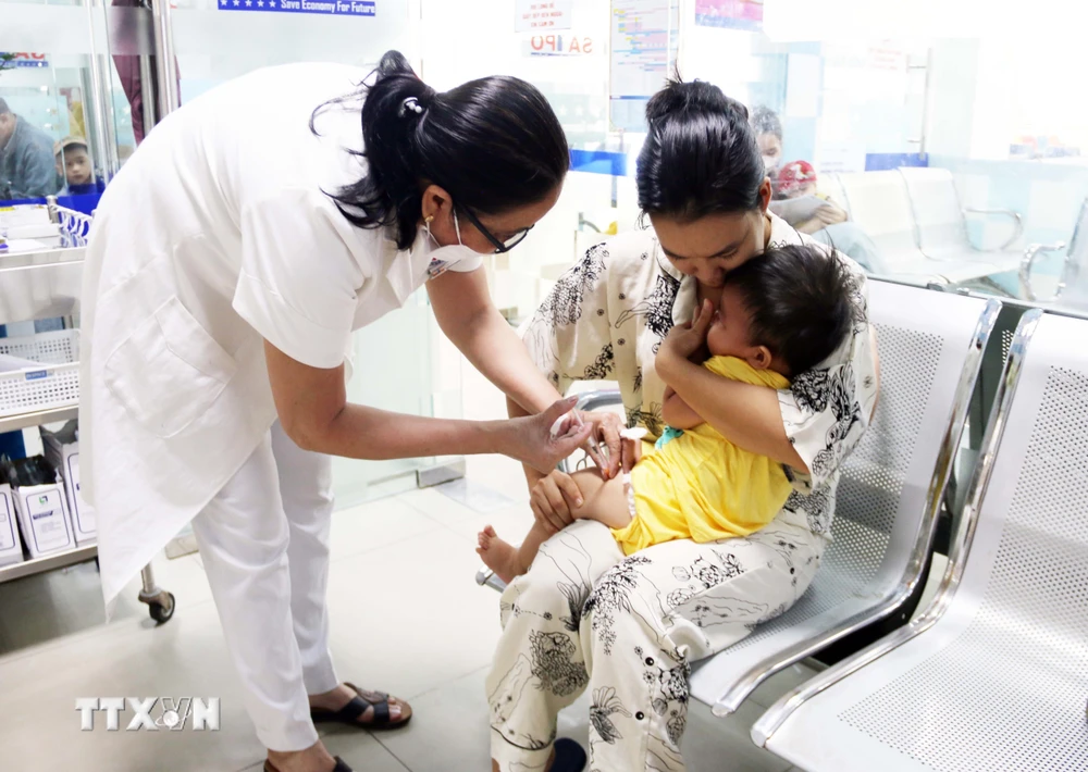 Nhân viên y tế tiêm vaccine phòng bệnh cho trẻ. (Ảnh: TTXVN/Vietnam+)