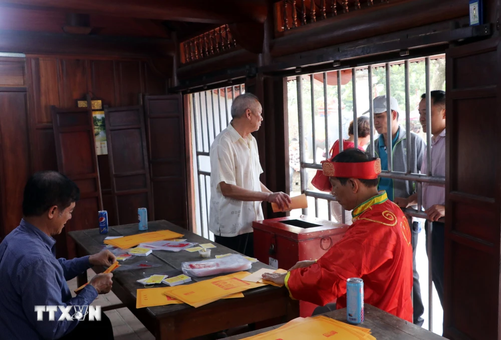 Các cụ cao niên phường Lộc Vượng, thành phố Nam Định (Nam Định) chuẩn bị ấn phát cho nhân dân, du khách. (Ảnh: Văn Đạt/TTXVN)