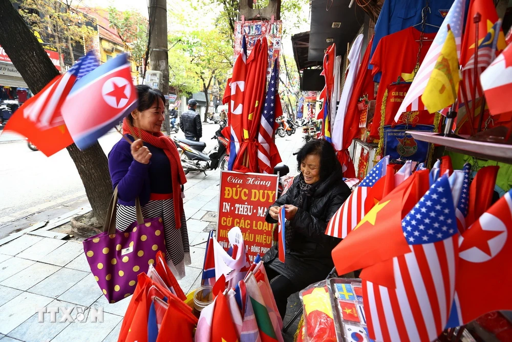 Trong ảnh: Khách du lịch mua cờ các nước trên phố Hàng Bông (Hà Nội). (Ảnh: Minh Quyết/TTXVN)