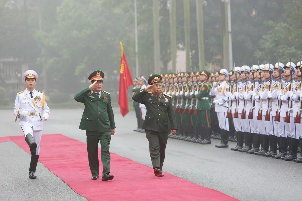 Đại tướng Lương Cường và Trung tướng Thongloi Silivong duyệt đội danh dự. (Ảnh: Dương Giang/TTXVN)