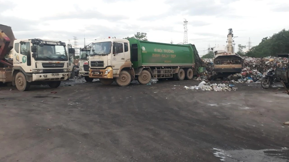 Công ty CP dịch vụ môi trường Thăng Long đang huy động tối đa phương tiện, nhân lực để thu dọn rác tồn đọng trên địa bàn quận Hoàng Mai. Ảnh Mạnh Khánh/TTXVN)