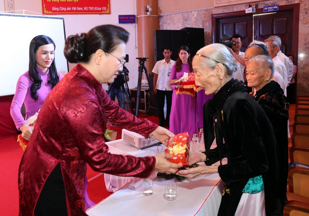 Chủ tịch Quốc hội Nguyễn Thị Kim Ngân tặng hoa và quà các Mẹ Việt Nam Anh hùng. (Ảnh: Trọng Đức/TTXVN)