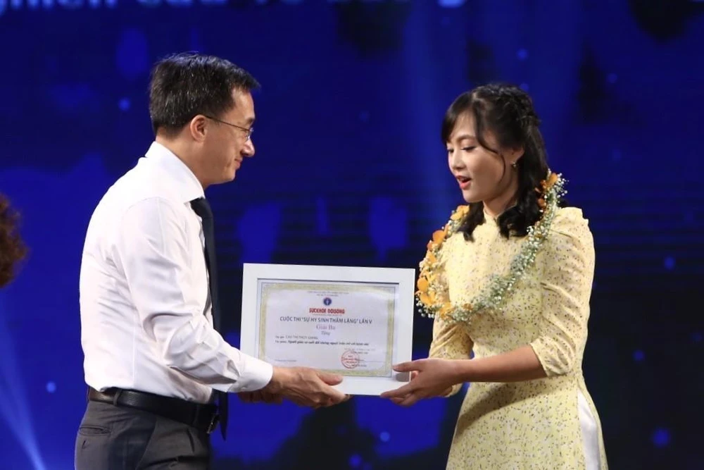 Ban tổ chức trao giải Nhì cho tác giả Cao Thùy Giang, báo Điện tử VietNamPlus. (Ảnh: Minh Quyết/TTXVN)