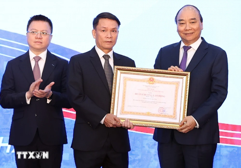 Thủ tướng Nguyễn Xuân Phúc, Chủ tịch Hội đồng Thi đua-Khen thưởng Trung ương, trao tặng Huân chương Lao động hạng Nhất cho Thông tấn xã Việt Nam. (Ảnh: Thống Nhất/TTXVN)