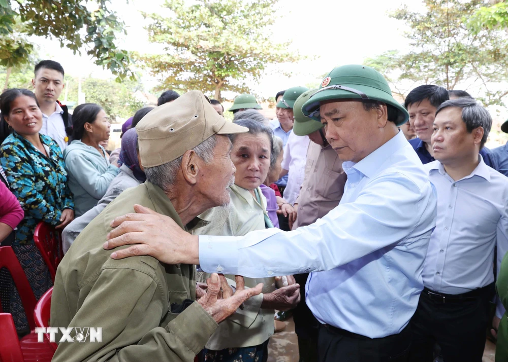 Thủ tướng Nguyễn Xuân Phúc thăm hỏi, chia sẻ khó khăn, mất mát với nhân dân thôn Đồng Tư, xã Hiền Ninh, huyện Quảng Ninh, tỉnh Quảng Bình. (Ảnh: Thống Nhất/TTXVN)