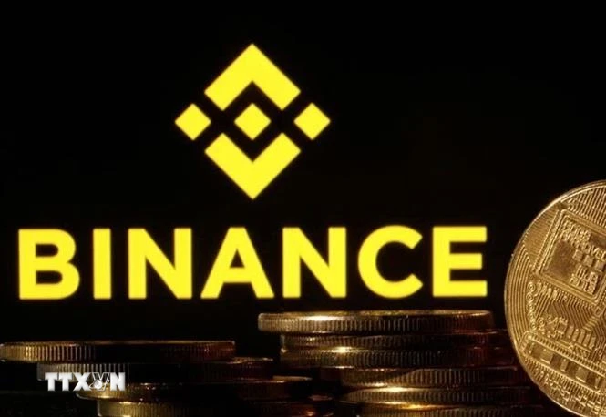 Đồng tiền Bitcoin và biểu tượng Binance. (Ảnh: Reuters/TTXVN)