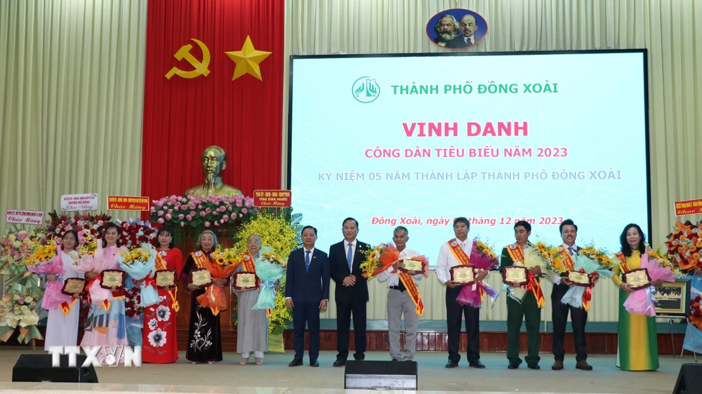 Lãnh đạo tỉnh Bình Phước và thành phố Đồng Xoài tuyên dương 10 công dân tiêu biểu thành phố. (Ảnh: Đậu Tất Thành/TTXVN)