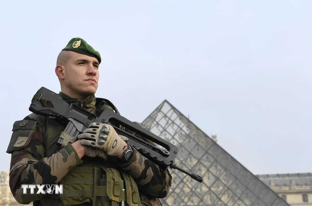 Cảnh sát gác tại lối vào Kim Tự tháp trong khuôn viên Bảo tàng Louvre ở Paris. (Ảnh: AFP/TTXVN)