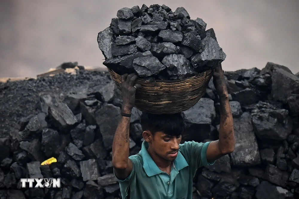 Thu nhặt than đá tại một khu mỏ ở ngoại ô Dhanbad, Ấn Độ. (Ảnh: AFP/TTXVN) 