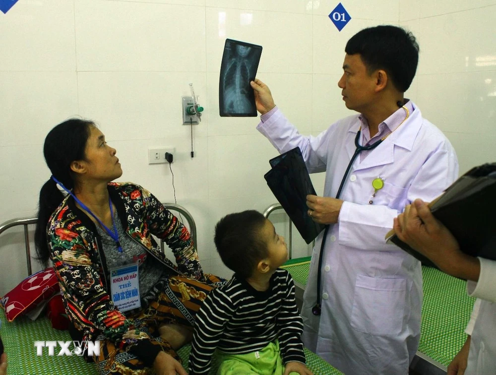 Bác sỹ Bệnh viện Sản nhi Nghệ An xem phim chụp XQ của bệnh nhi. (Ảnh: Tá Chuyên/TTXVN) 