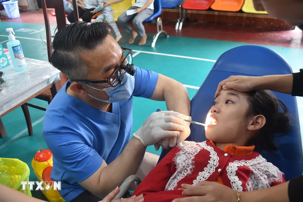 Các bác sỹ tiến hành thăm, khám răng cho trẻ em tại Đắk Lắk. (Ảnh: Nguyên Dung/TTXVN)