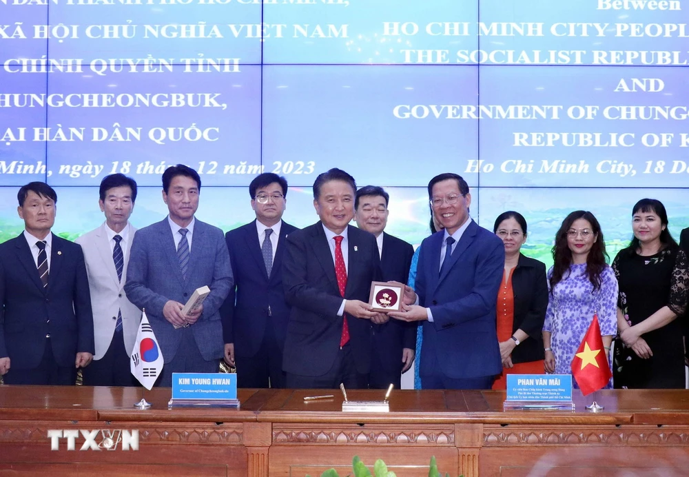 Ông Phan Văn Mãi (bên phải), Chủ tịch Ủy ban Nhân dân Thành phố Hồ Chí Minh trao tặng quà cho ông Kim Yong Hwan, Tỉnh trưởng tỉnh Chungcheongbuk, Hàn Quốc. (Ảnh: Xuân Khu/TTXVN)