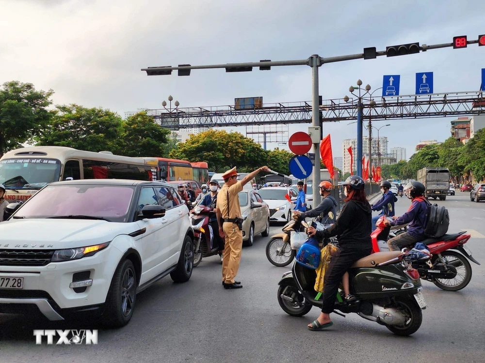 Lực lượng Cảnh sát giao thông nỗ lực điều tiết, hướng dẫn các phương tiện di chuyển. (Ảnh: TTXVN phát)