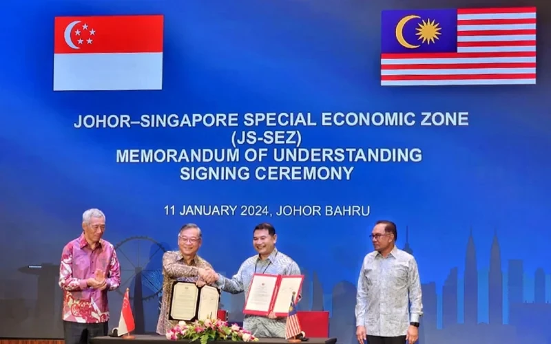 Bộ trưởng Kinh tế Malaysia Rafizi Ramli (thứ 2 từ phải sang) và Bộ trưởng Thương mại và Công nghiệp Singapore Gan Kim Yong ký biên bản ghi nhớ thành lập Đặc khu Kinh tế Johor-Singapore. (Nguồn: Bernama)