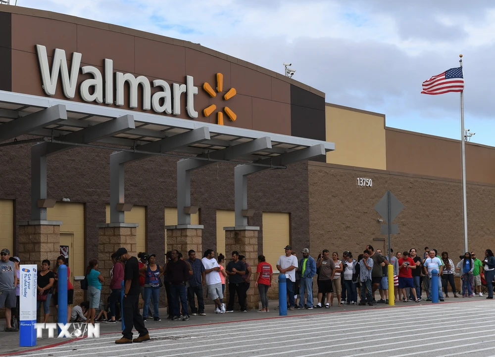 Người dân xếp hàng bên ngoài cửa hàng Walmart ở Houston, Texas, Mỹ. (Ảnh: AFP/TTXVN)