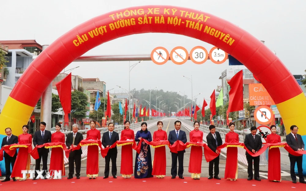 Các đại biểu thực hiện nghi thức cắt băng thông xe kỹ thuật cầu vượt đường sắt Hà Nội-Thái Nguyên. (Ảnh: Hoàng Nguyên/TTXVN)