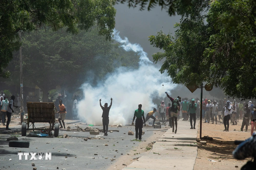 Người biểu tình quá khích ném đá về phía cảnh sát tại Dakar, Senegal, ngày 1/6/2023. (Ảnh: AFP/TTXVN)