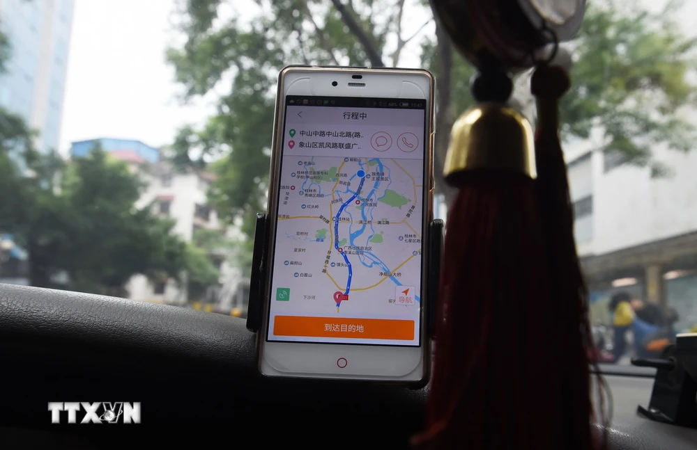 Tài xế taxi sử dụng ứng dụng gọi xe Didi Chuxing tại Quế Lâm, Trung Quốc. (Ảnh: AFP/TTXVN)