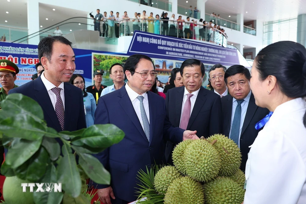 Thủ tướng Phạm Minh Chính tham quan gian trưng bày, giới thiệu sản phẩm nông nghiệp của tỉnh Vĩnh Long. (Ảnh: Dương Giang/TTXVN)