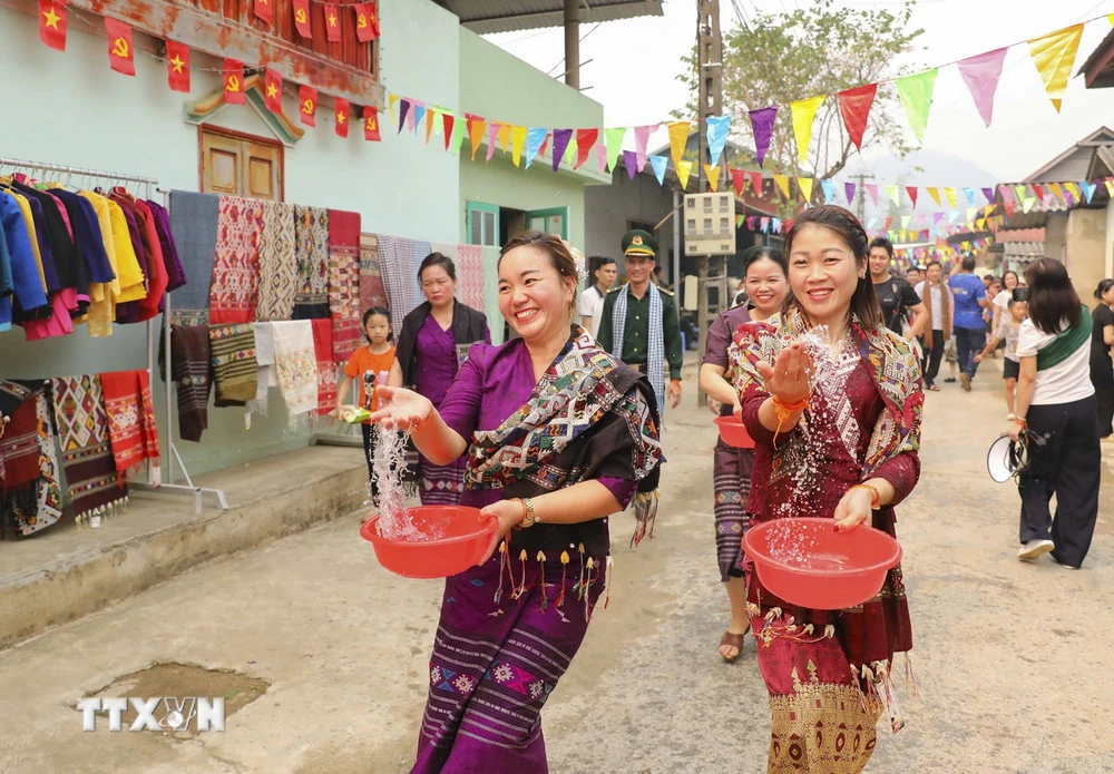 Những cô gái dân tộc Lào té nước cầu may. (Ảnh: Xuân Tư/TTXVN)