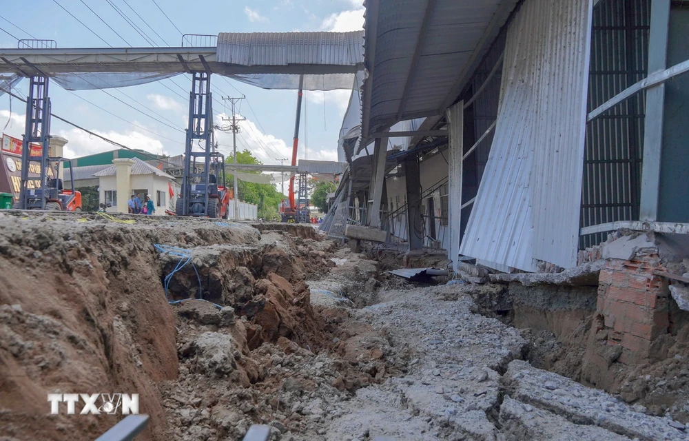 Nhà kho của Công ty Lương thực Hưng Phước bị sụt lún sâu so với mặt đường tỉnh 921. (Ảnh: Thanh Liêm/TTXVN)