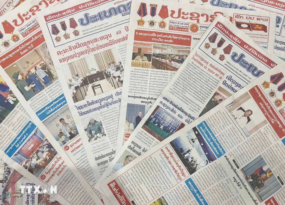 Trang nhất báo Pasaxon và báo Pathet Lao trong những ngày vừa qua đưa tin đậm nét về Chiến thắng Điện Biên Phủ. (Ảnh: Đỗ Bá Thành/TTXVN)