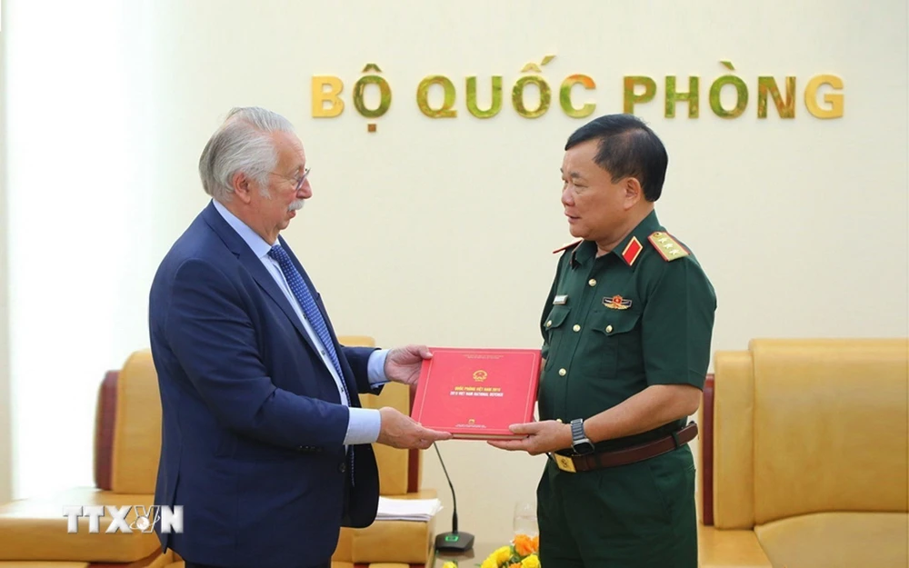 Thượng tướng Hoàng Xuân Chiến (phải) trao tặng ngài André Flahaut Sách trắng Quốc phòng Việt Nam 2019. (Ảnh: Hồng Pha/TTXVN phát)