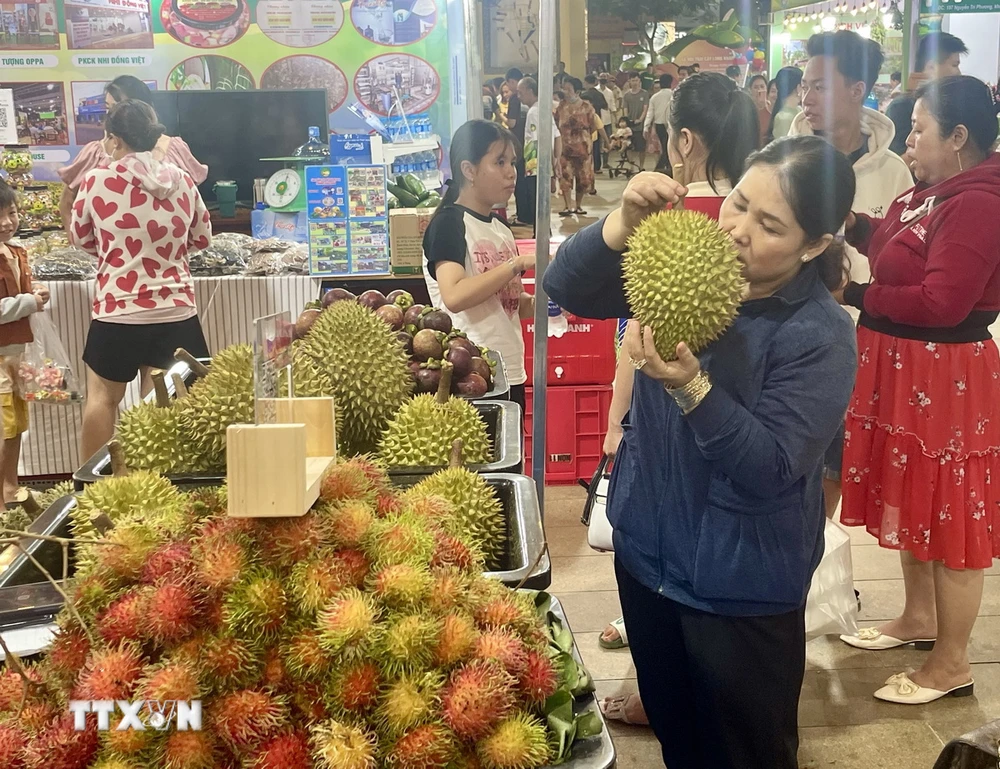 Du khách trong và ngoài tỉnh tham quan, mua sắm các đặc sản trai cây Long Khánh tại lễ hội. (Ảnh: Lê Xuân/TTXVN)