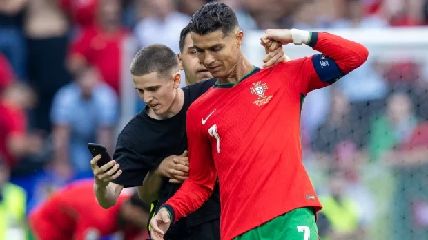 Một cổ động viên lao xuống sân, cố chụp ảnh selfie với Cristiano Ronaldo. (Nguồn: Getty Images)