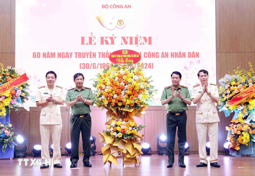 Trung tướng Lê Quốc Hùng, Ủy viên Trung ương Đảng, Thứ trưởng Bộ Công an, tặng hoa chúc mừng Tạp chí Công an Nhân dân. (Ảnh: Phạm Kiên/TTXVN)