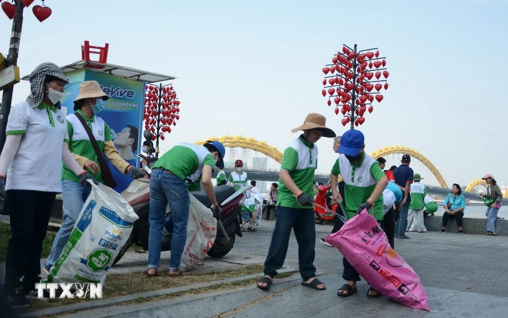 Thanh niên, người dân tham gia nhặt rác dọc ven sông Hàn (đường Trần Hưng Đạo, quận Sơn Trà, Đà Nẵng). (Ảnh: Văn Dũng/TTXVN)