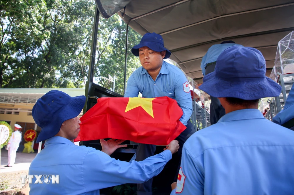 Cán bộ, chiến sỹ các Đội tìm kiếm, quy tập hài cốt liệt sỹ đưa các hài cốt liệt sỹ quân tình nguyện Việt Nam hy sinh tại Campuchia về Nghĩa trang liệt sỹ Đồi 82, huyện Tân Biên. (Ảnh: Giang Phương/TTXVN)